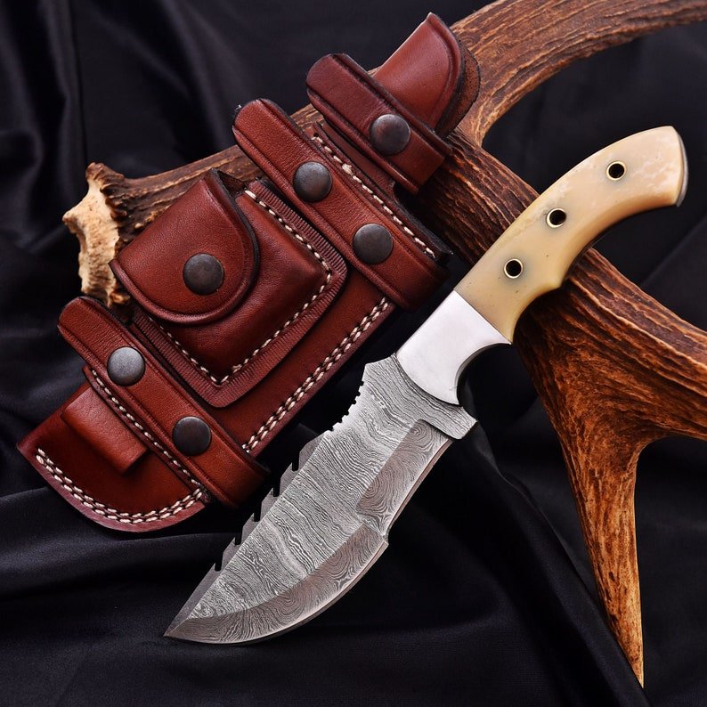 Tracker knife with full tang steel blade, durable handle, and leather sheath for outdoor survival
