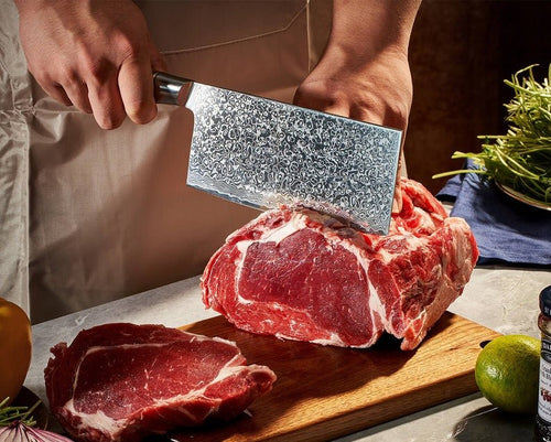 Person cutting raw meat on a wooden board with a large knife.