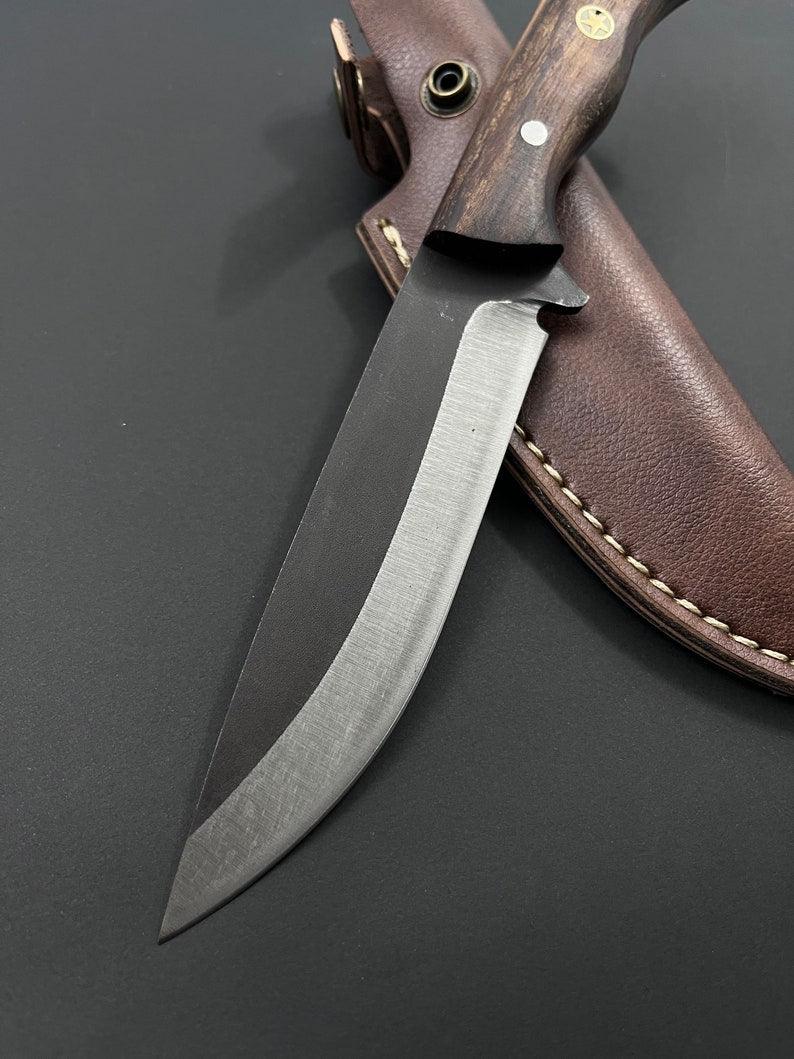 Handmade skinner knife with sharp curved steel blade and ergonomic handle for hunting and skinning tasks
