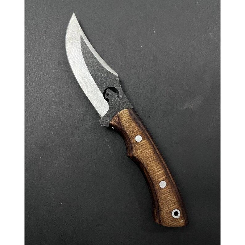 Handmade skinner knife with sharp curved steel blade and ergonomic handle for hunting and skinning tasks
