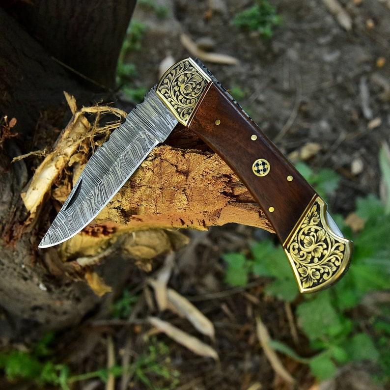 Damascus folding knife with patterned steel blade, ergonomic handle, and secure locking mechanism by Viking Hills
