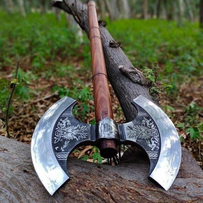 A double-edged axe with a wooden handle and a steel head, resting on a wooden stump in a natural outdoor setting.