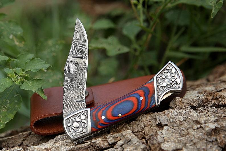 Damascus folding knife with patterned steel blade, ergonomic handle, and secure locking mechanism by Viking Hills
