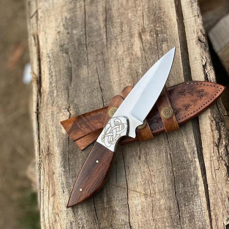 Handmade skinner knife with sharp curved steel blade and ergonomic handle for hunting and skinning tasks
