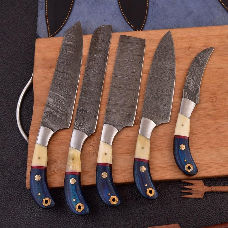 Set of five knives with decorative handles on a wooden board