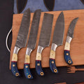 Set of five knives with decorative handles on a wooden board