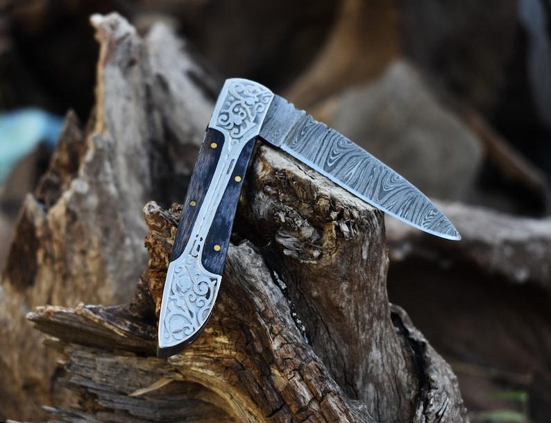 Damascus folding knife with patterned steel blade, ergonomic handle, and secure locking mechanism by Viking Hills
