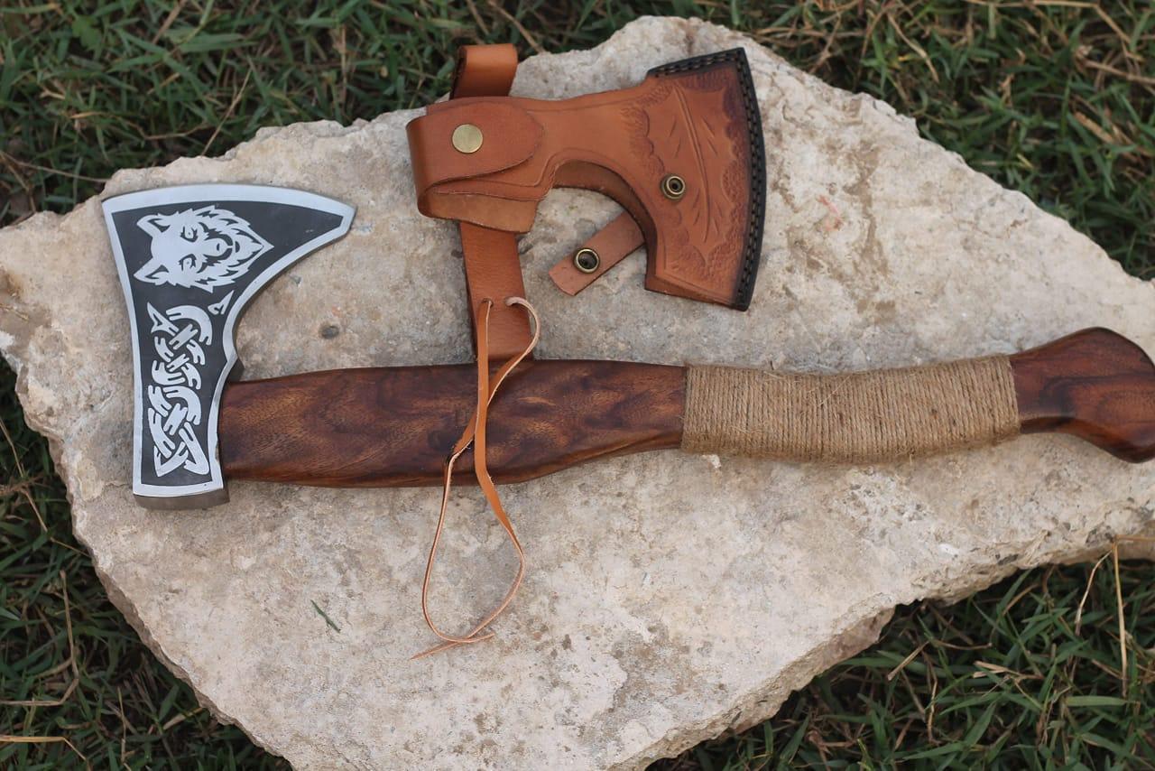 A handmade Viking axe with a leather cover, featuring a wooden handle and a steel head with engraved details.