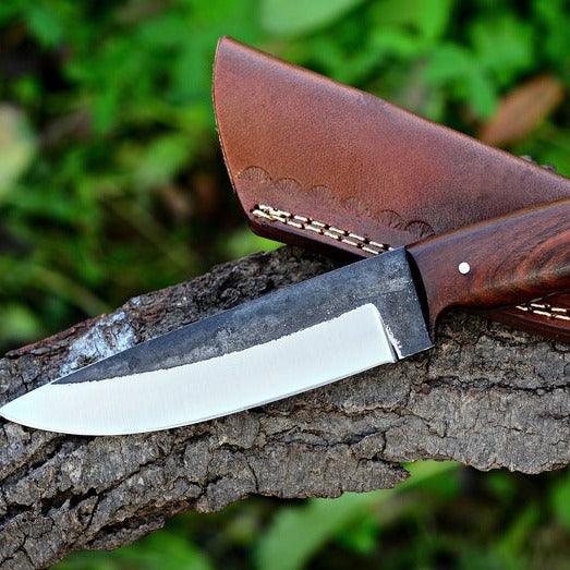 Handmade skinner knife with sharp curved steel blade and ergonomic handle for hunting and skinning tasks
